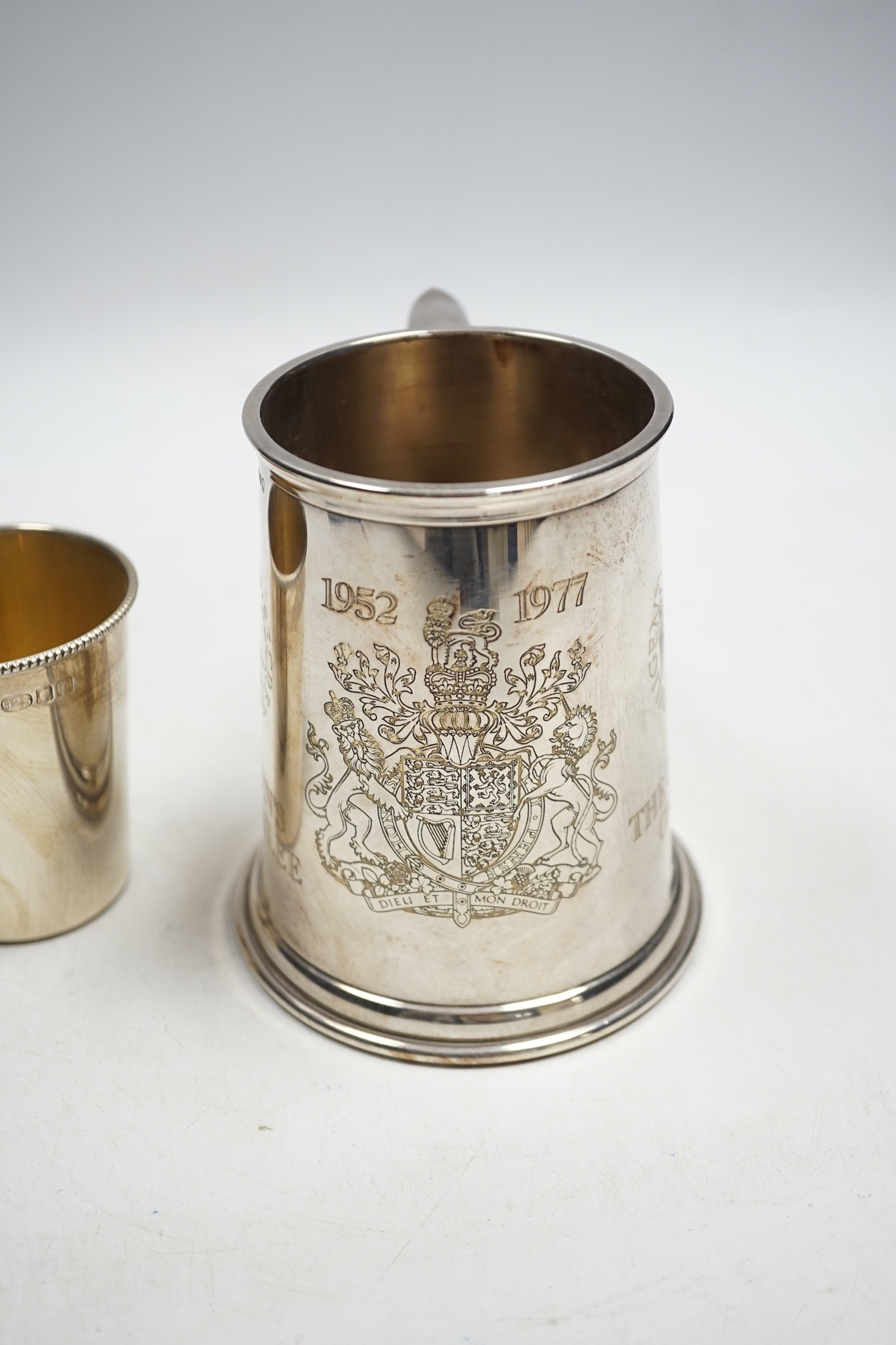 A modern silver QE11 Silver Jubilee Collage of Arms commemorative mug, 12cm, together with a modern silver beaker by WW, 13.5oz.